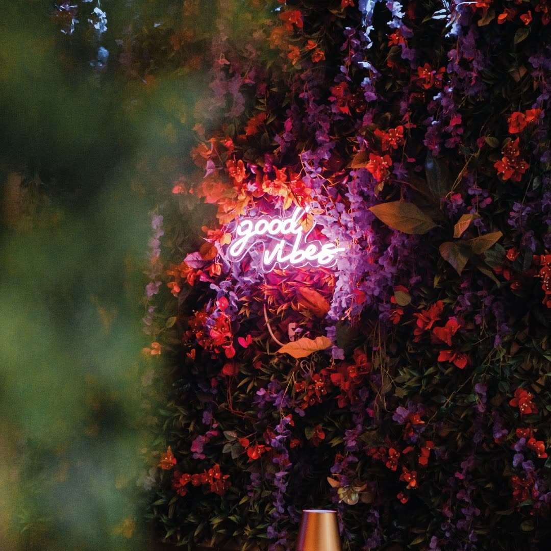 L'insegna al neon good vibes tra i fiori