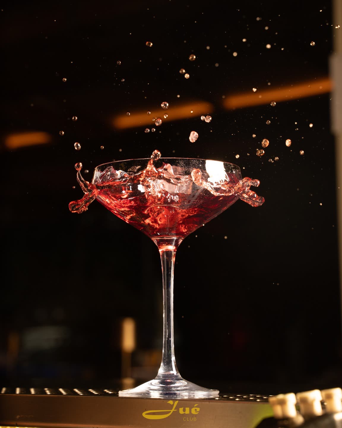 Un cocktail rosso in una coppa che schizza